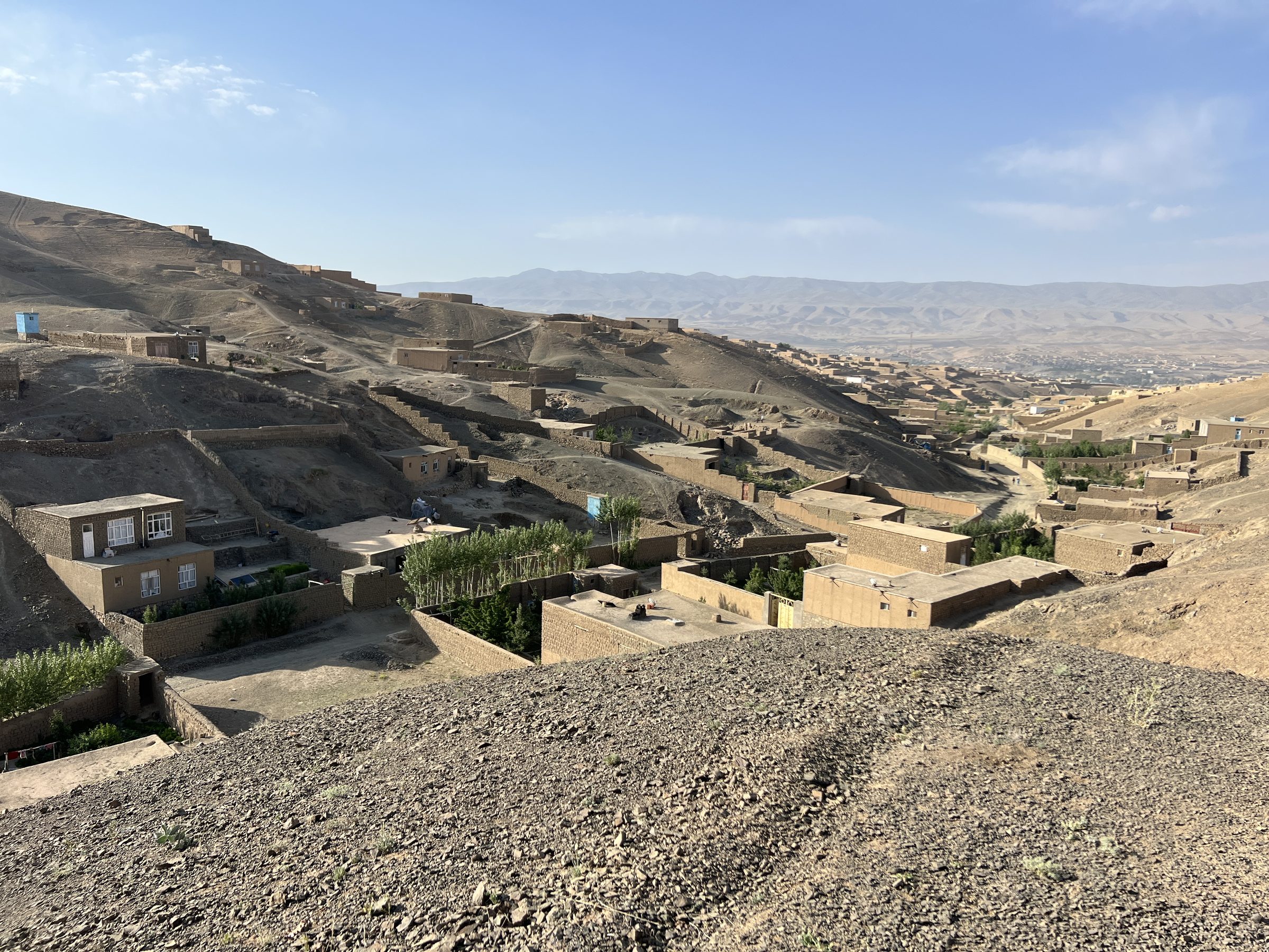 Hillside adobe village in Ghor province against the high-desert mountains