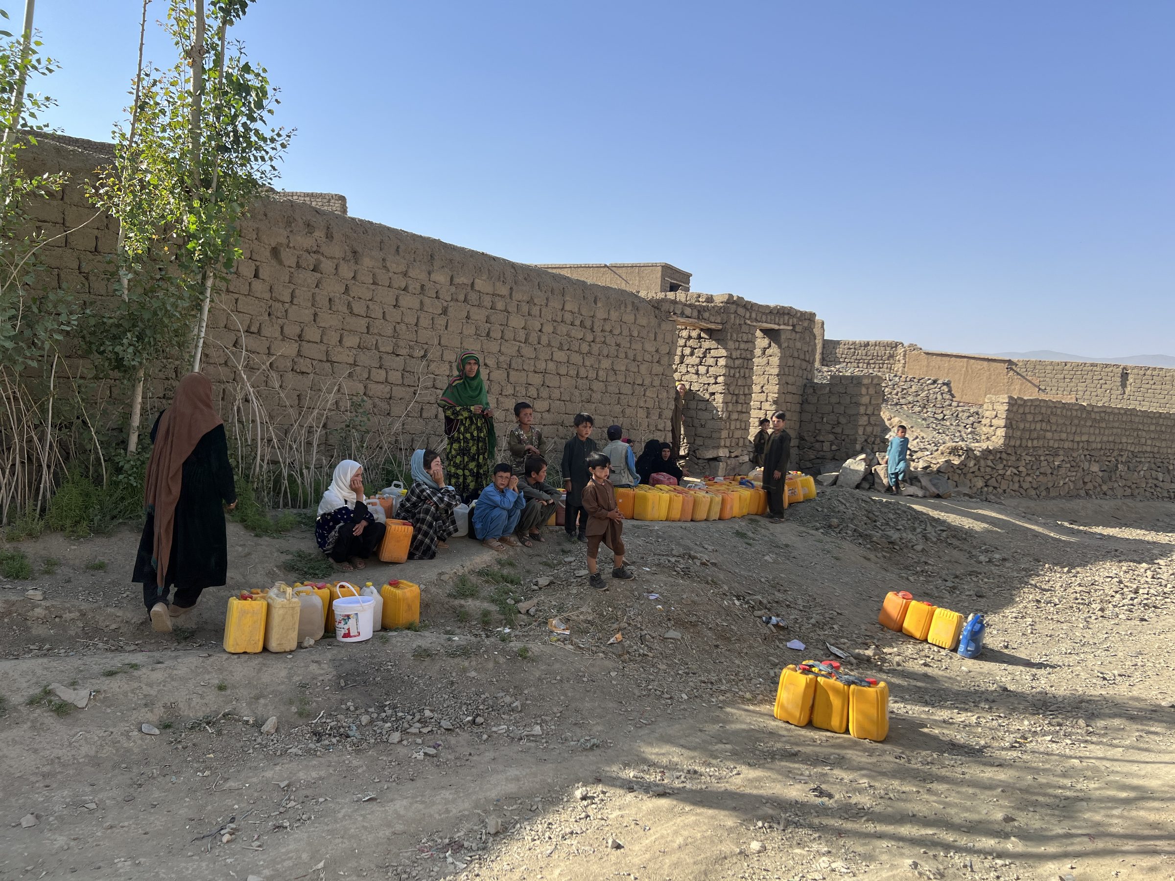 Women and children waiting beside their water containers in Ghor
