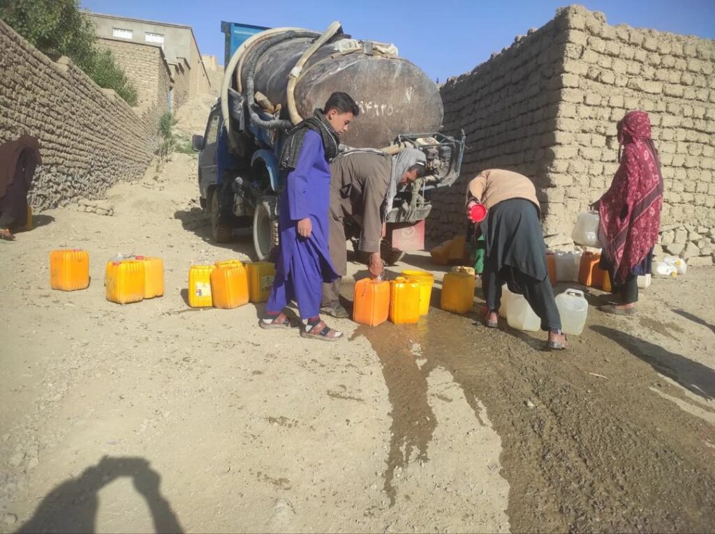 A water tanker filling jerrycans for families in Ghor