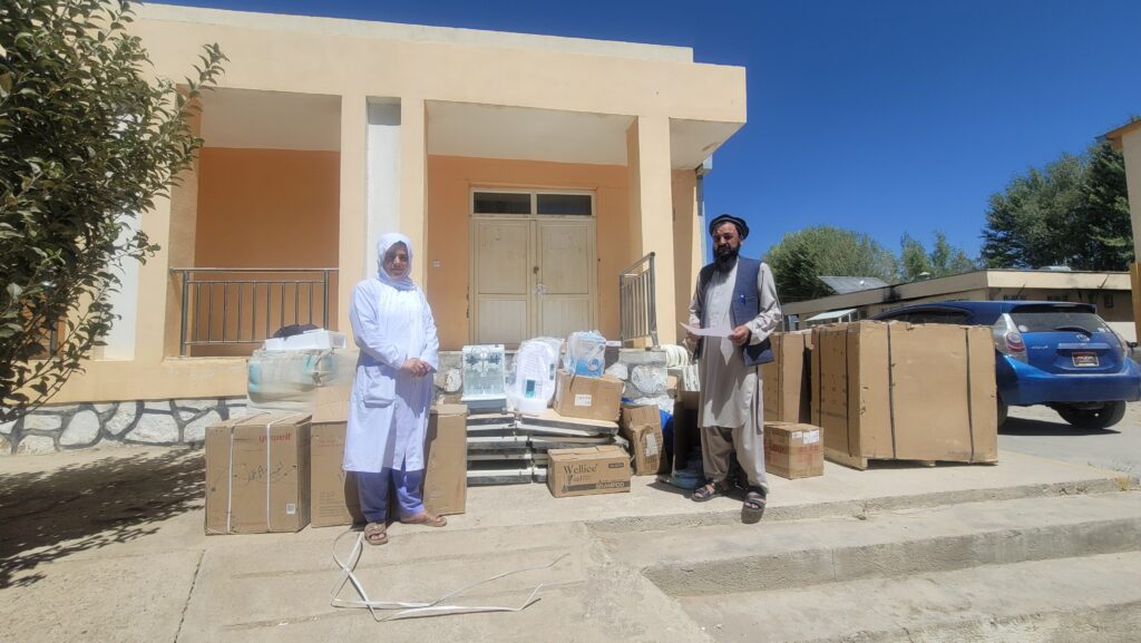 A health worker and community elder with locally delivered program equipment in Ghor